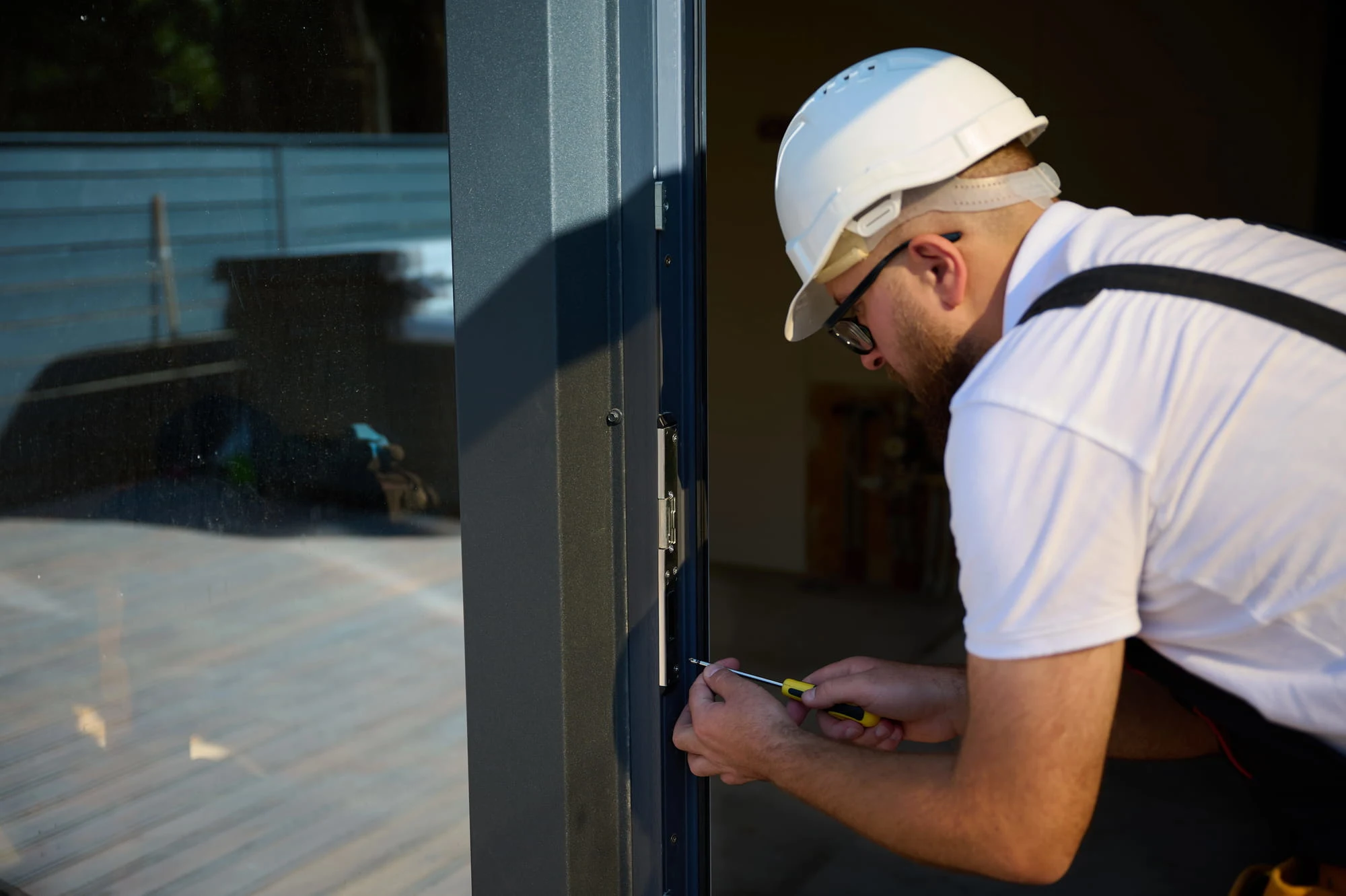 Technician fitting hinge and strike hardware to a commercial door frame in Charlotte, NC